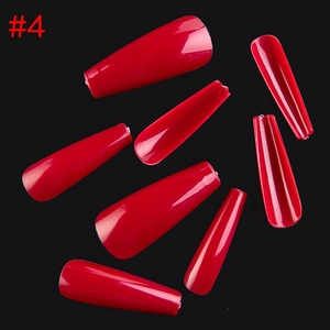 Flat lay of red coffin-shaped press-on nails in different sizes on black background