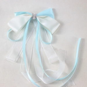 Detail of blue and white satin bow hair clip with elegant pearl and rhinestone center