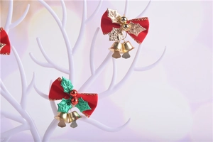 Detail of red Christmas bows with holly leaves and gold bells on white branches