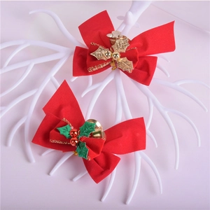 Red Christmas bows with gold and red bells and holly leaves on white branches