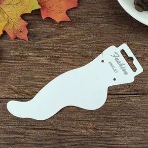 Professional white cardstock anklet display card with Fashion lettering on wood background