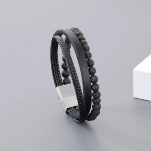 Detail view of men's multilayered black leather bracelet with volcanic stone beads