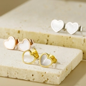Detail of heart-shaped 18K gold earrings in gold, silver, and rose gold finishes