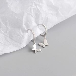 Gros plan détaillé des créoles papillon en argent sterling S925 avec diamants brillants