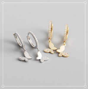 Détail macro de créoles papillon en argent et or avec sertissage pavé de zircones