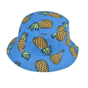 Detail of blue bucket hat featuring vibrant pineapple patterns and cotton fabric texture