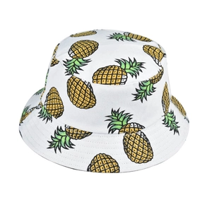 Close-up of vibrant pineapple print on a white cotton summer bucket hat detail