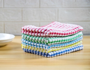 Close-up of five colorful checkered cotton tea towels stacked neatly on a wooden table