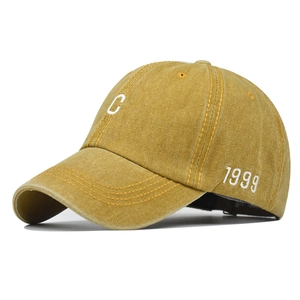Detailed close-up of vintage yellow washed cotton baseball cap with C embroidery