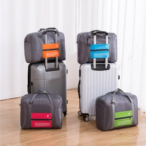 Foldable grey travel organizer bag with colorful pockets and luggage handle sleeve