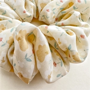 Floral chiffon scrunchie with yellow and red flowers on a beige elastic hair band