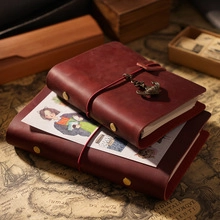 Detail showing vintage burgundy crazy horse leather journal with anchor charm and elastic band