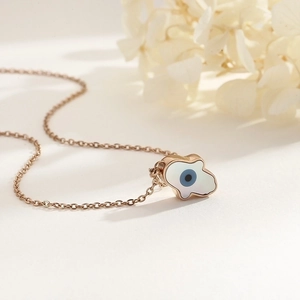 Detail of rose gold evil eye necklace with white shell inlay and elegant O-chain