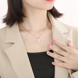 Close-up of 18k gold plated Hamsa hand necklace with Evil Eye pendant on a model