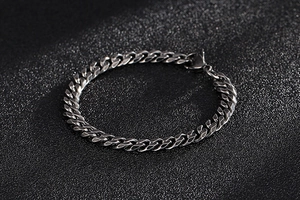 Close-up of polished silver stainless steel Cuban link bracelet with lobster clasp