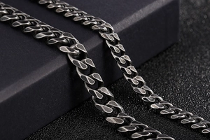 Macro detail of retro gun-black flat Cuban link chain with vintage matte industrial finish