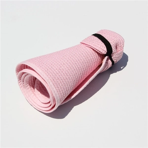 Detail of pink woven sun hat in folded state showing portability and black elastic strap