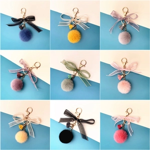 Variety of plush ball keychains with lace bows and tassels in nine colorful styles