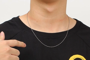 Close-up of a silver stainless steel ball bead chain necklace worn by a male model