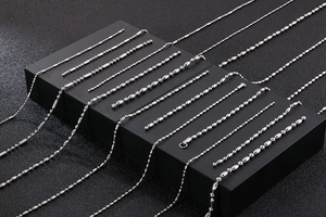 Detail of silver stainless steel ball chains in various styles on black display