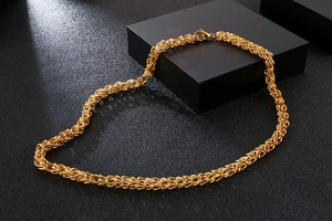 Close-up of golden braided stainless steel chain with intricate dragon link weave