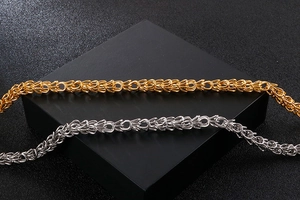 Detail shot of woven gold and silver link chains showcasing premium metallic texture