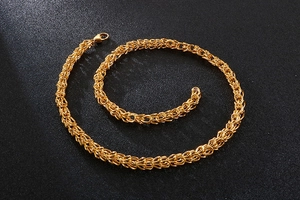 Detailed view of golden woven chain necklace spiraled on a professional black background