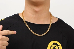 Close-up of gold crown chain necklace on model's neck for hip-hop street style