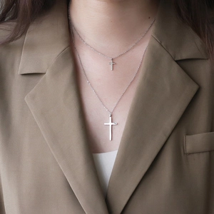 Collana a doppio strato in argento con croce su modella con blazer color marrone