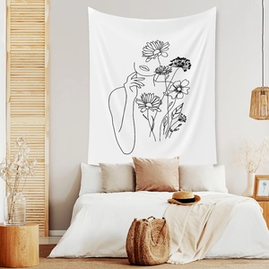 Detail of minimalist white tapestry with black line art of woman and flowers on fabric