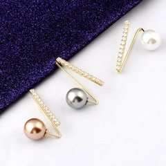 Close-up of golden horse-shaped brooches with champagne pearls and sparkling zircons