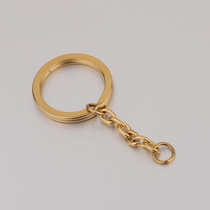 Macro shot of mirror-polished gold stainless steel 25mm flat key ring with extension chain