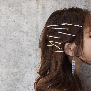 Close-up of sparkling silver rhinestone hair clips and matching earrings on a model