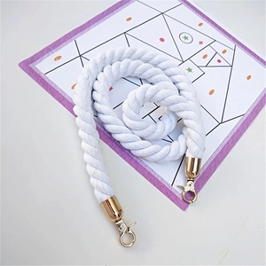 Detail of white cotton twisted bag strap with gold metal lobster clasps on background