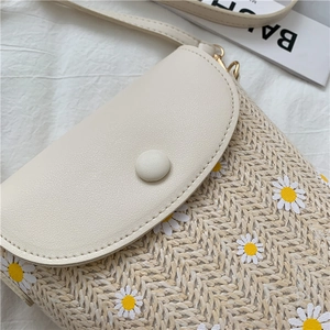 Detail of straw bucket bag with white daisy embroidery and cream PU leather flap