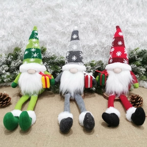 Tre gnomi natalizi a gambe lunghe con cappelli a fiocchi e piccole scatole regalo