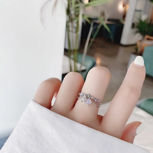 Close-up of sparkling floral ring with lavender and blue crystals on hand