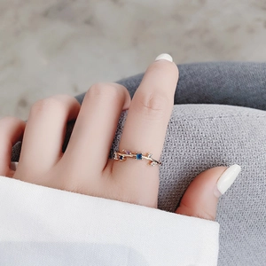 Close-up of gold branch ring with blue and purple crystals on a model finger