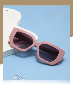 Detail of pink thick rectangle sunglasses with polarized lenses on a display prop