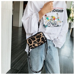 Close-up of leopard print hard shell mini crossbody bag with 'FOREVER YOUNG' strap