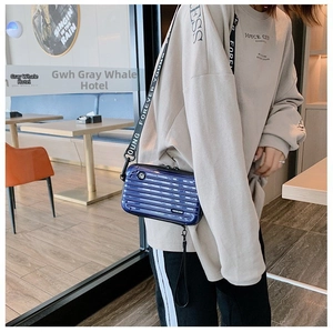 Detail of dark blue mini suitcase bag with vertical stripes and Forever Young wide strap