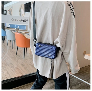 Mini hardshell suitcase crossbody bag in deep blue mirror finish with wide nylon strap