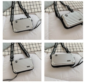 Detail view of silver mini suitcase crossbody bag with Forever Young strap branding