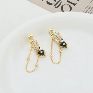 Elegant gold earrings with micro-pave zircons and blue heart pendants in a white plate