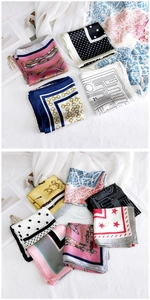 Macro detail of various printed silk square scarves with elegant patterns and smooth texture