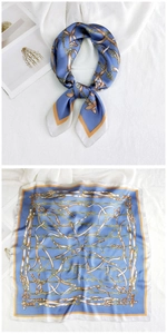 Detail of silk square scarf featuring classic equestrian chain patterns in blue and gold