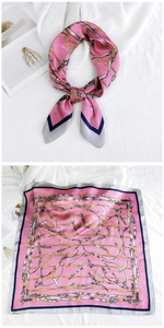 Detail of pink silk square scarf with vintage gold chain and leather belt pattern