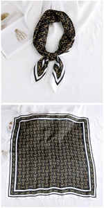Detail of silk square scarf featuring classic horsebit pattern with black and gold accents