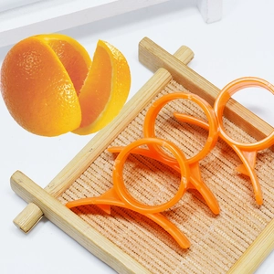 Three-piece set of orange plastic ring peelers with hook blade on a bamboo mat