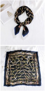 Detail of silk square scarf featuring gold chain and brown belt patterns on navy blue